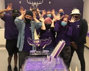 Purple Moose Cannabis staff stand together using their hands as antlers