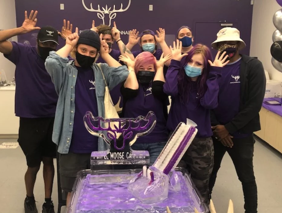 Purple Moose Cannabis staff holding their hands up like antlers
