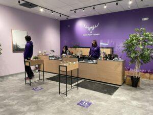 The checkout counter at Purple Mosoe cannabis Lawrence with staff members
