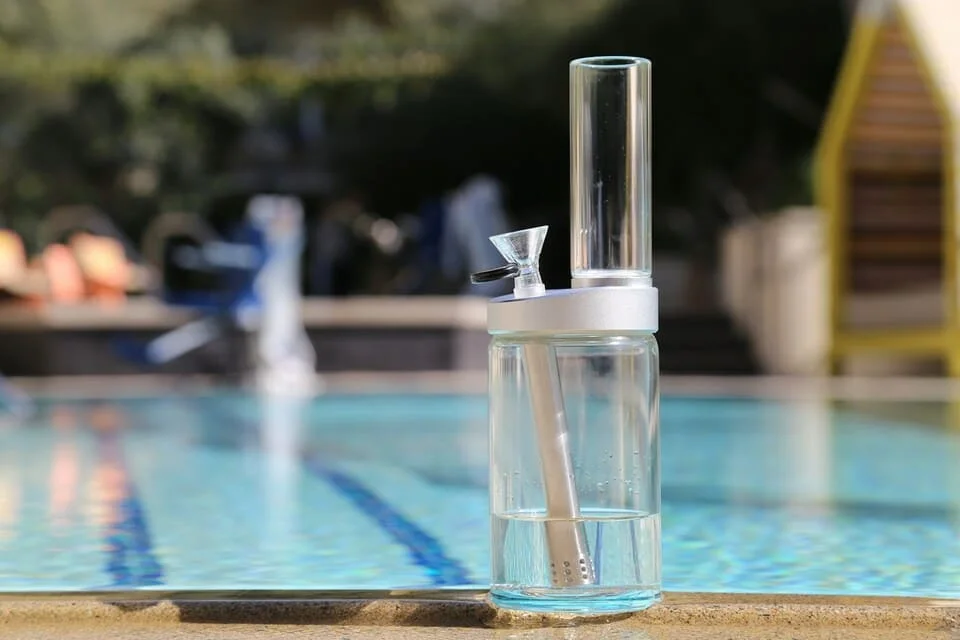 Clear glass weed bong by poolside